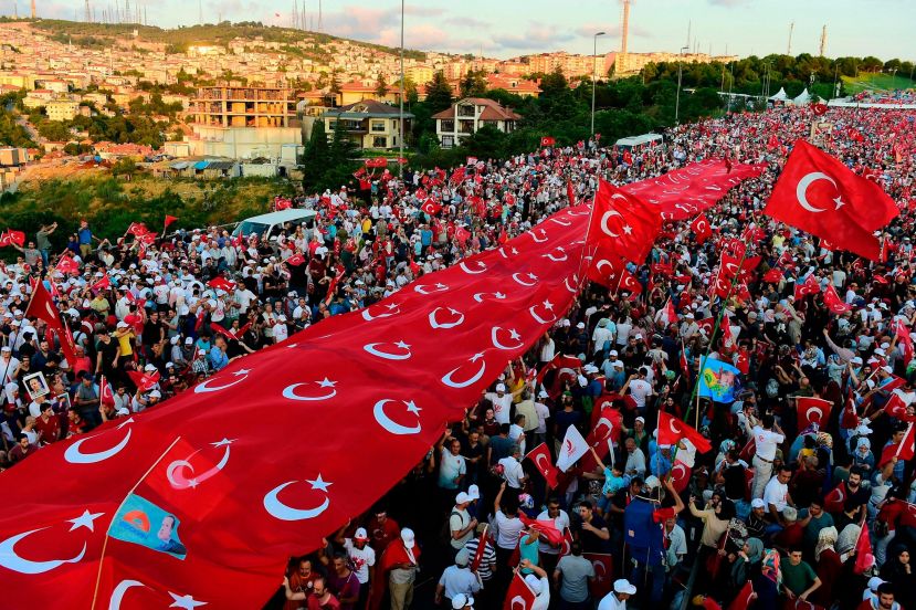  Turks standing under a collection of Turkish national flags on Saturday in Istanbul. 