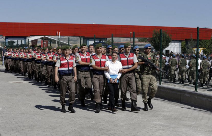   Paramilitary police and members of the special forces escort unidentified suspects of last year&#039;s failed coup outside the courthouse at the start of the trial Tuesday in Ankara, Turkey. 