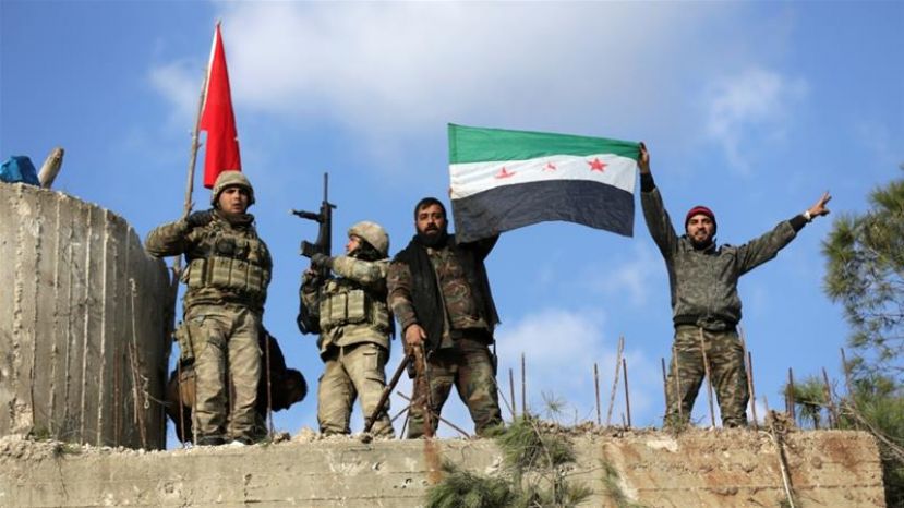 Turkish troops and Free Syrian Army fighters hold flags on Mount Barsaya, northeast of Afrin, Syria on January 28 [Reuters/Khalil Ashawi] 