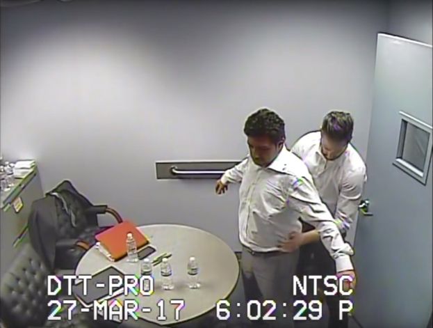 Taken from federal surveillance footage, this still image shows U.S. authorities frisking Mehmet Hakan Atilla after his arrest on March 27, 2017. A former manager at the Turkish state-run bank Halkbank, Atilla is being tried in New York over transactions that flouted sanctions against Iran.
